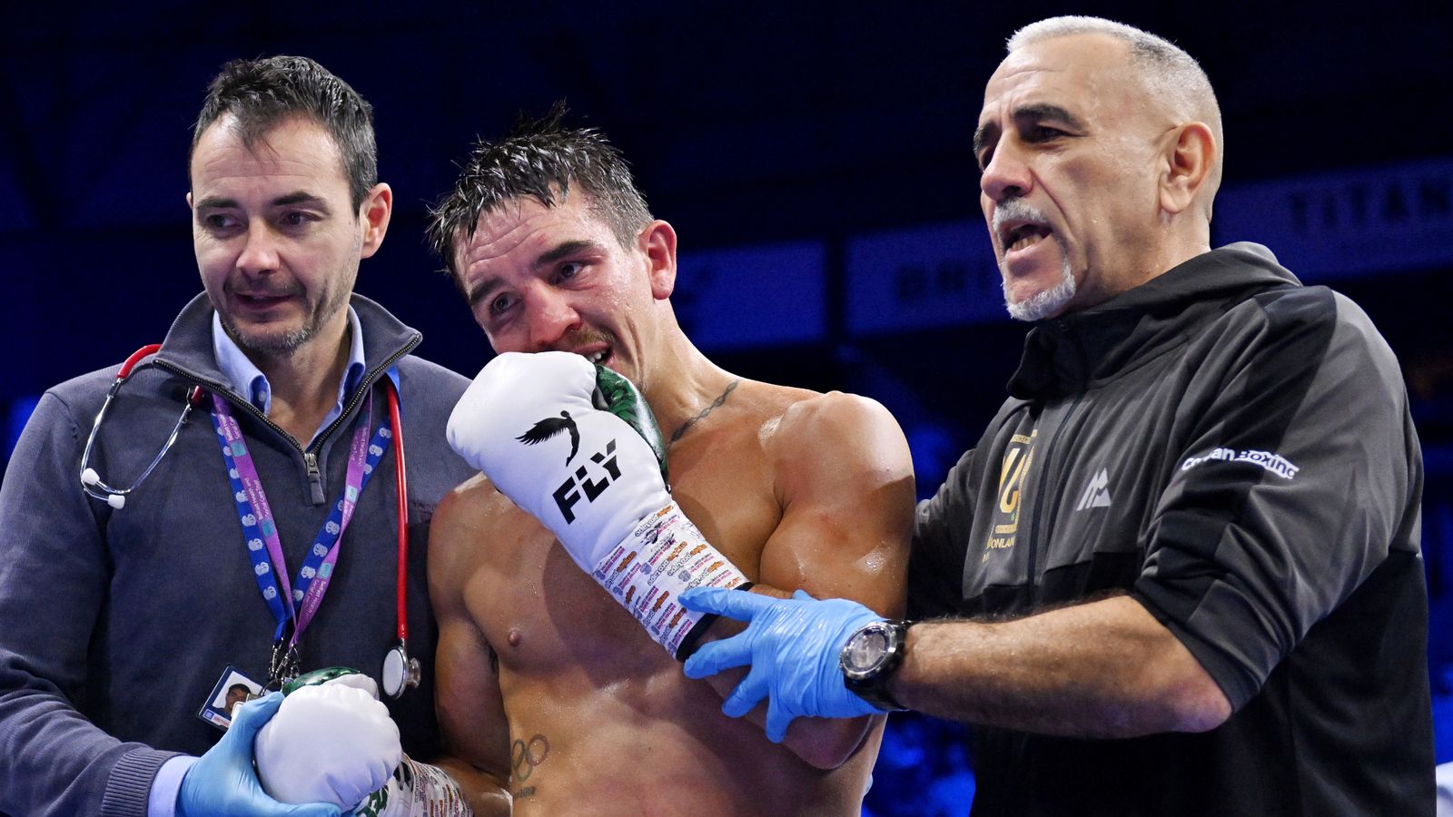 Michael Conlan is helped to his corner by medical staff and a coach after the Referee stops the fight, leading to victory for Jordan Gill after defeating Michael Conlan, during the WBA International Super Featherweight Title fight